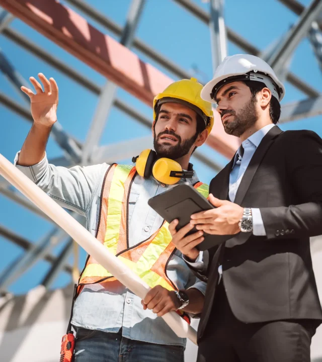 civil-engineer-construction-worker-manager-holding-digital-tablet-blueprints-talking-planing-about-construction-site-cooperation-teamwork-concept
